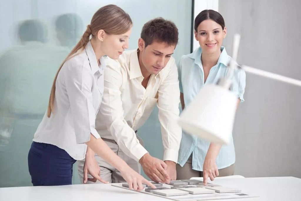 Three colleagues standing in a bright office