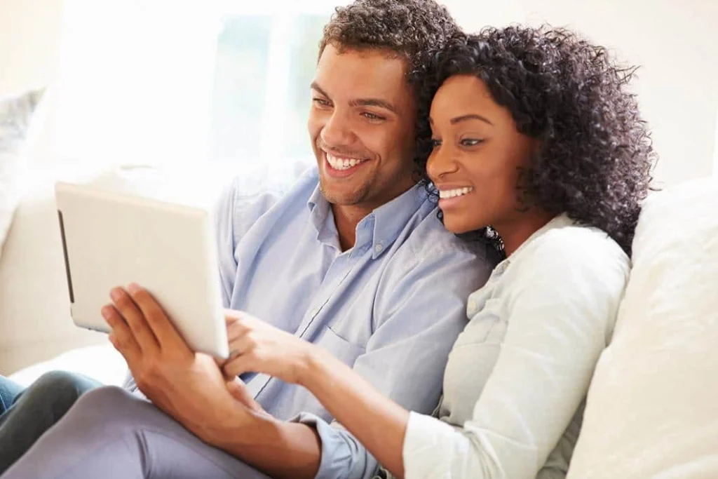 Couple reading tablet on a sofa together in a bright room