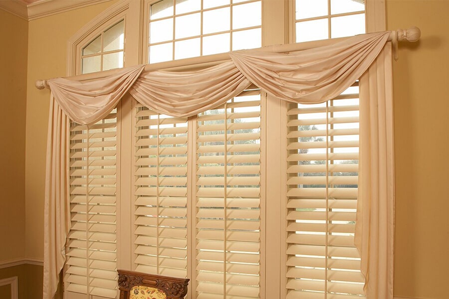 Elegant dining room with white shutters and decorative valance