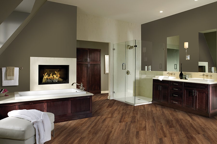 Luxurious bathroom with waterproof dark wood flooring and fireplace