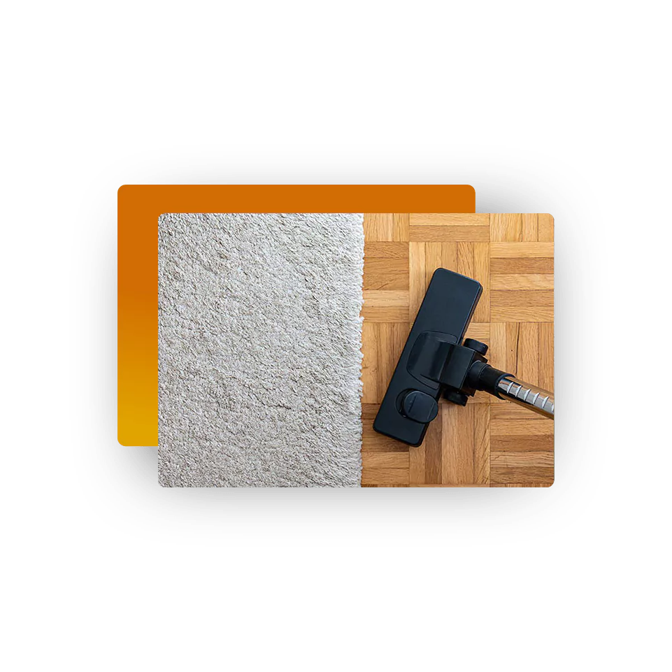 Vacuum cleaner on a hardwood floor beside a light-colored area rug, illustrating daily area rug care