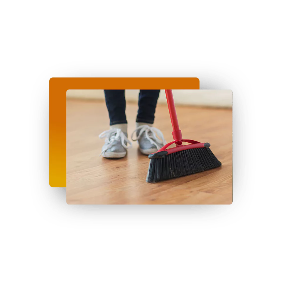 Sweeping luxury vinyl flooring with a broom to maintain cleanliness