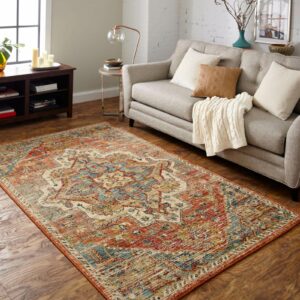 Ornate red and gold area rug in a traditional living room with dark wood floors