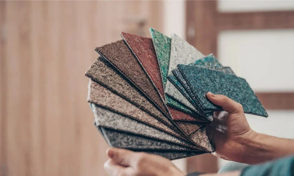 Person holding synthetic fiber carpet swatches