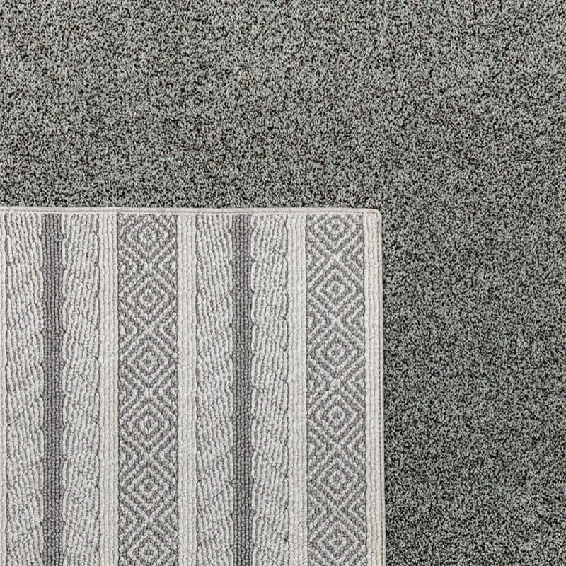 Geometric patterned area rug on carpet